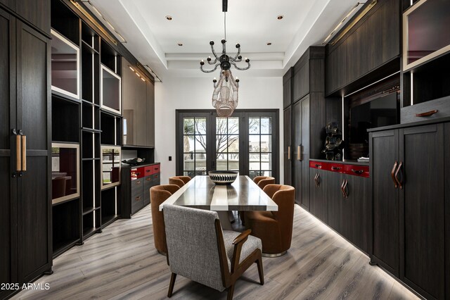 dining room with a tray ceiling and light wood finished floors