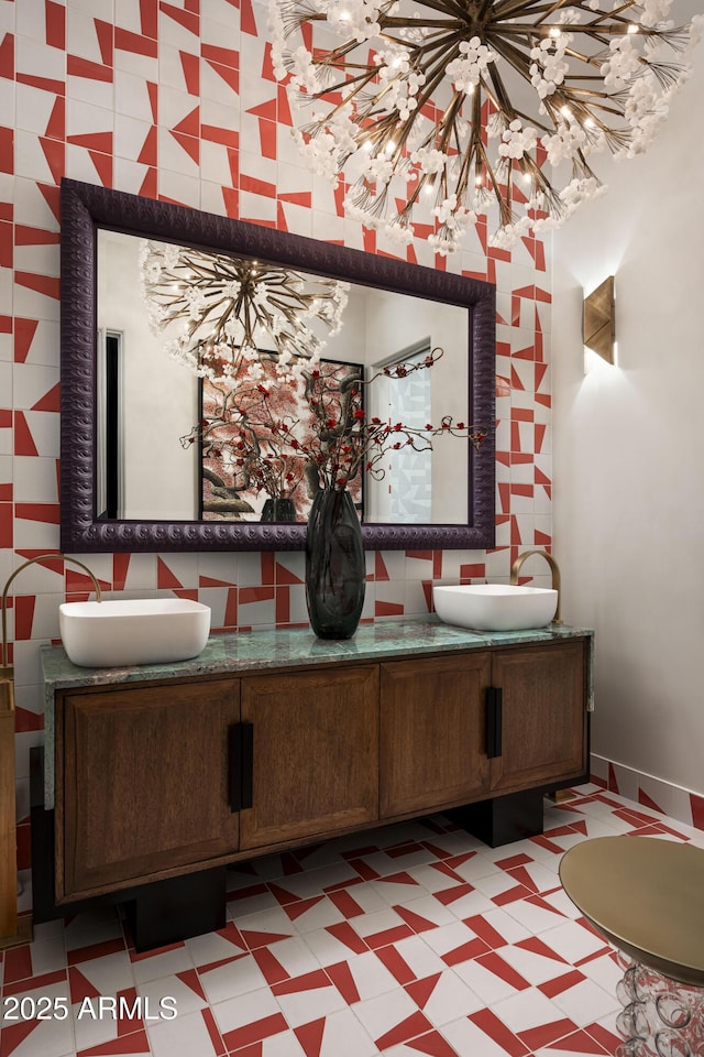 bathroom featuring a sink, baseboards, and double vanity