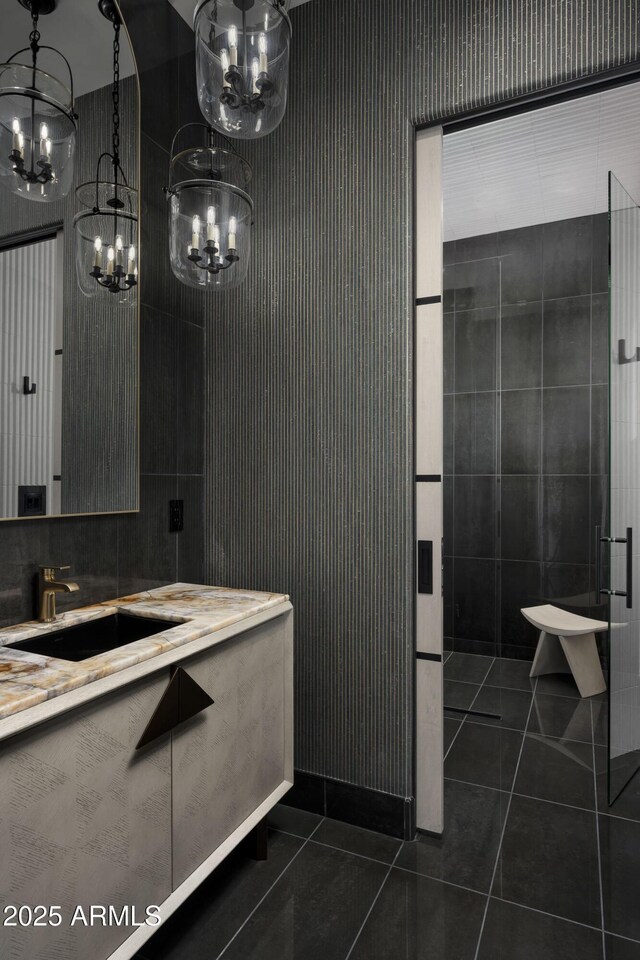 full bathroom with tile patterned flooring, vanity, and a notable chandelier