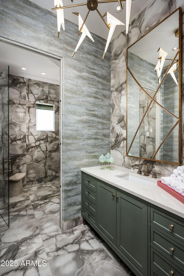 bathroom featuring marble finish floor, vanity, and a walk in shower