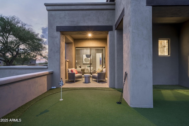 entrance to property featuring a patio area and stucco siding