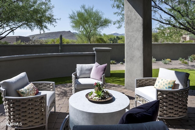 view of patio / terrace featuring a mountain view, an outdoor living space, and fence