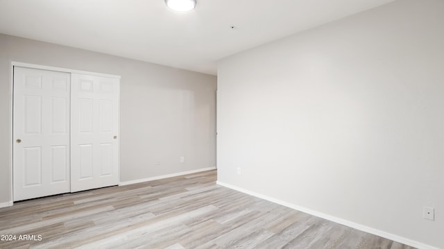 unfurnished bedroom with light hardwood / wood-style floors and a closet