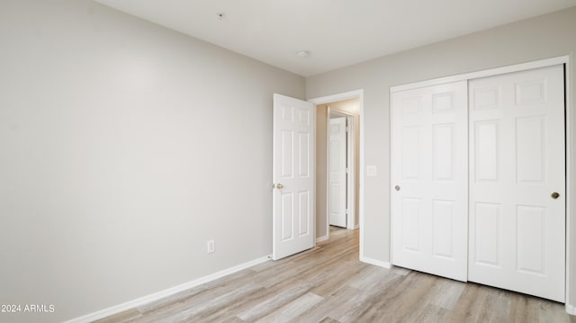 unfurnished bedroom featuring a closet and light wood-type flooring