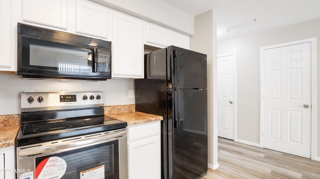 kitchen featuring black appliances, white cabinetry, light stone counters, and light hardwood / wood-style flooring