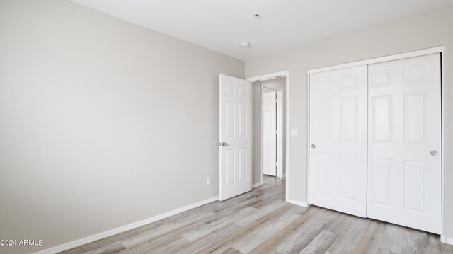 unfurnished bedroom featuring a closet and light hardwood / wood-style flooring