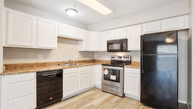 kitchen with white cabinetry, black appliances, sink, and light hardwood / wood-style floors