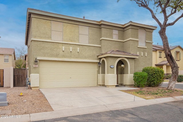 view of front of property with an attached garage, fence, a tile roof, driveway, and stucco siding