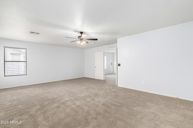 carpeted empty room featuring ceiling fan, visible vents, and baseboards