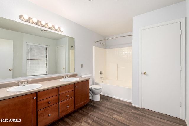 full bath featuring double vanity, toilet, a sink, and wood finished floors