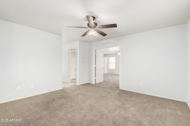 spare room with light colored carpet, ceiling fan, visible vents, and baseboards