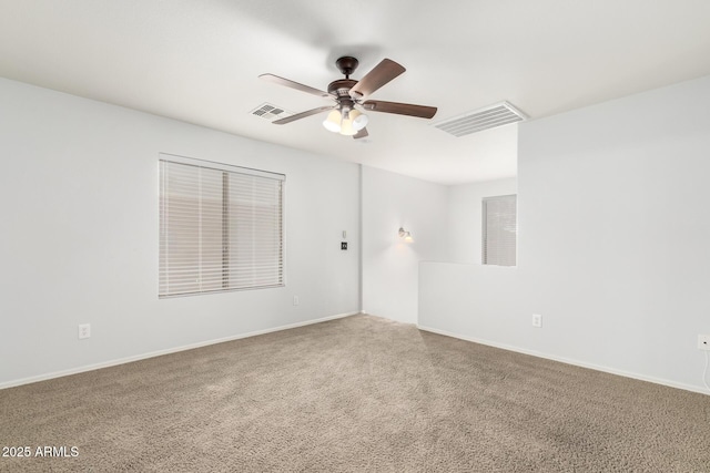 unfurnished room featuring carpet floors, ceiling fan, visible vents, and baseboards