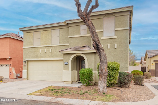 view of front of property featuring a garage, concrete driveway, a tile roof, and stucco siding