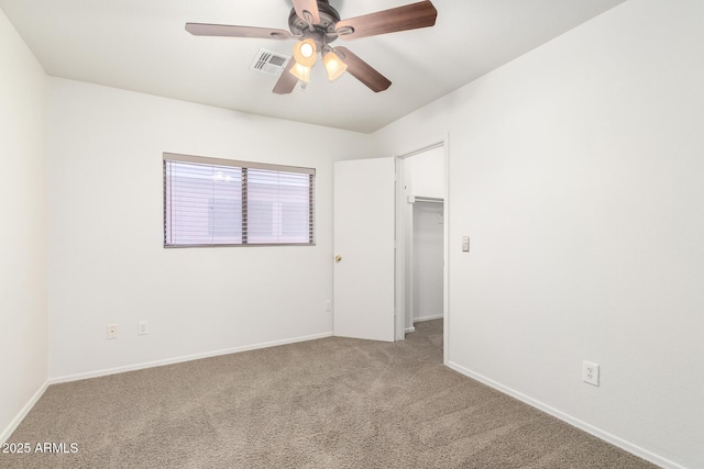 unfurnished bedroom featuring carpet floors, a spacious closet, visible vents, and baseboards