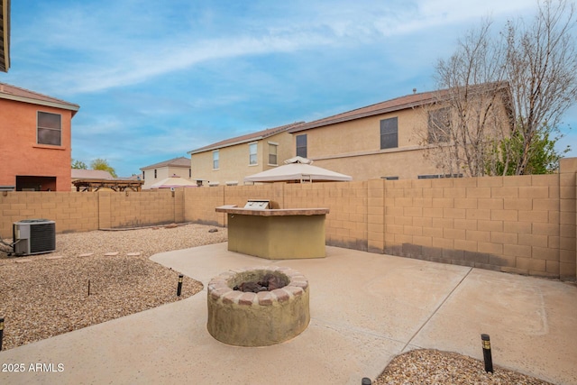 view of patio with a fire pit, central AC unit, and a fenced backyard