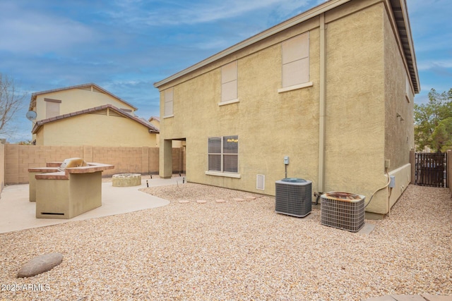 rear view of property featuring cooling unit, a patio area, a fenced backyard, and stucco siding