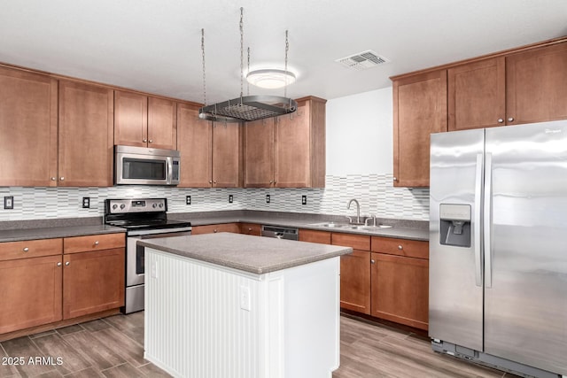 kitchen featuring light wood-type flooring, visible vents, stainless steel appliances, and a sink