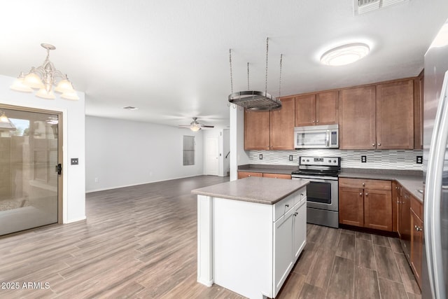 kitchen with stainless steel appliances, dark wood-type flooring, visible vents, open floor plan, and backsplash