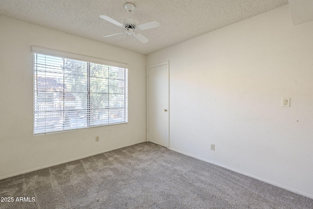 empty room with a ceiling fan, carpet flooring, and a textured ceiling