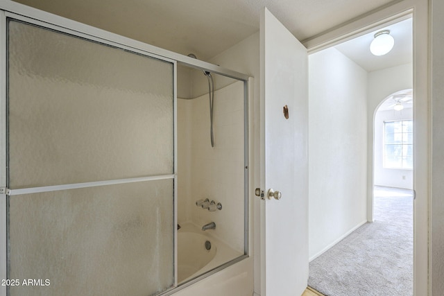 bathroom with combined bath / shower with glass door and baseboards