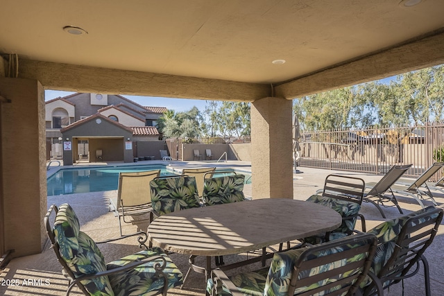 view of patio / terrace featuring fence and a community pool