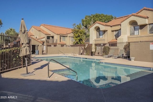 pool featuring a patio area, a residential view, and fence