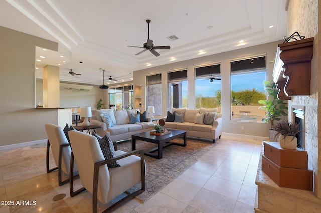 living room featuring a tray ceiling, ceiling fan, and light tile patterned floors