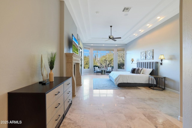 bedroom featuring a raised ceiling and ceiling fan