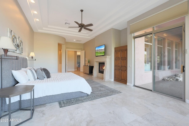 bedroom featuring ceiling fan, a raised ceiling, and access to outside