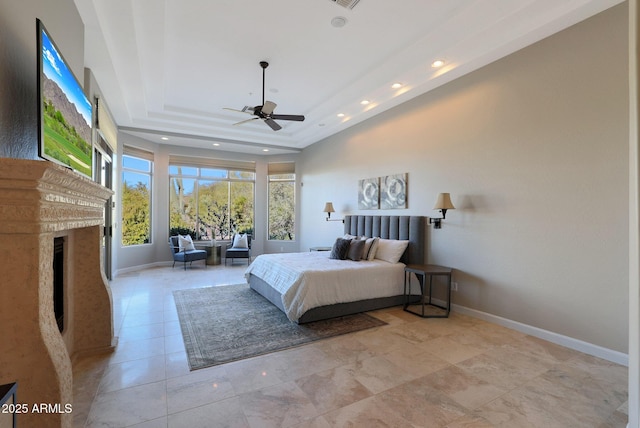 bedroom featuring a raised ceiling and ceiling fan