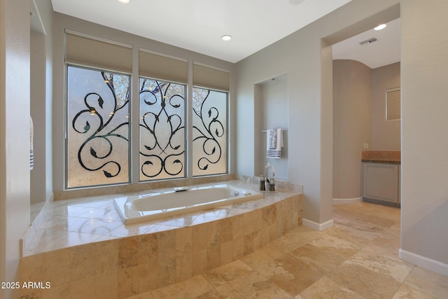 bathroom featuring vanity and tiled bath