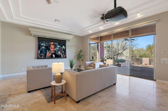 tiled living room featuring ceiling fan and a raised ceiling