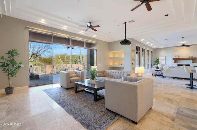 living room featuring a tray ceiling, ceiling fan, and built in features