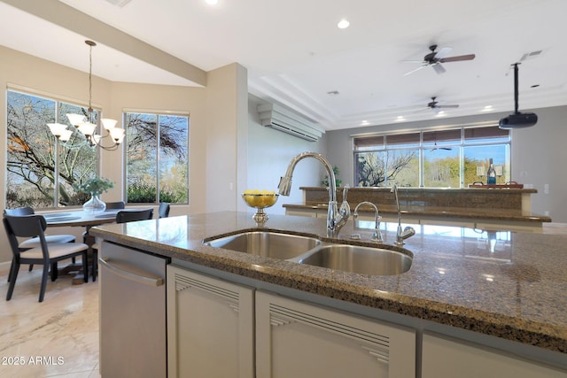 kitchen featuring dark stone counters, ceiling fan with notable chandelier, sink, decorative light fixtures, and dishwasher