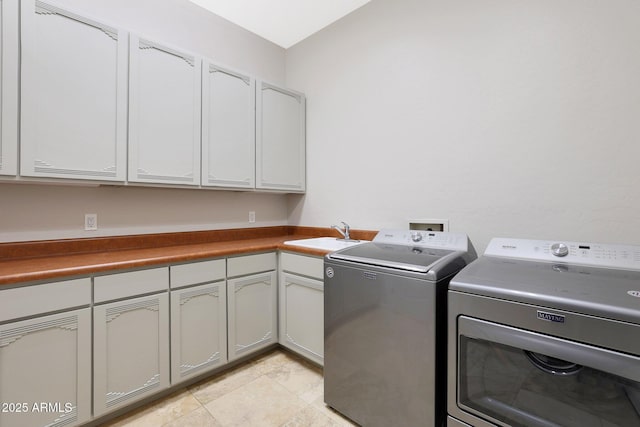 laundry room featuring cabinets, light tile patterned floors, washer and clothes dryer, and sink