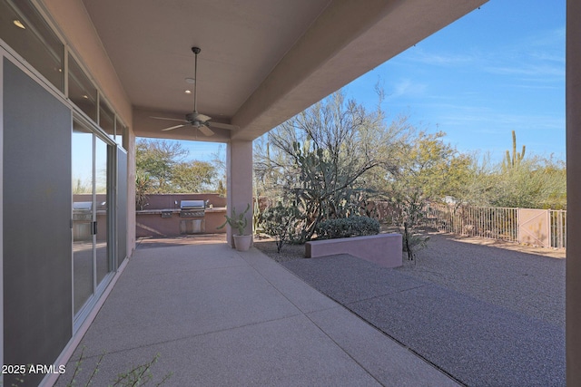 view of patio / terrace with ceiling fan, area for grilling, and a grill