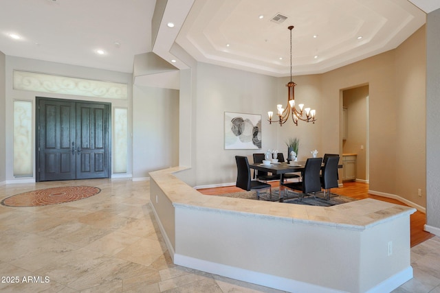 dining space featuring an inviting chandelier and a tray ceiling