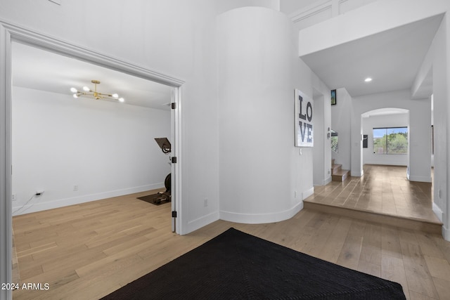 hall featuring an inviting chandelier and light hardwood / wood-style flooring