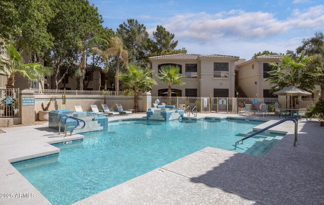 pool with a patio and fence