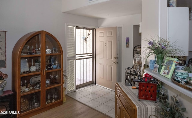 entrance foyer with light tile patterned floors and a healthy amount of sunlight