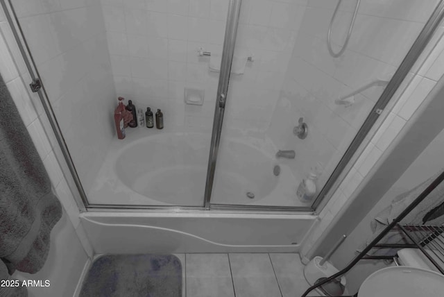 bathroom featuring toilet, shower / bath combination with glass door, and tile patterned floors