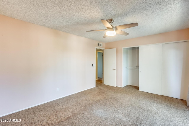 unfurnished bedroom with visible vents, ceiling fan, carpet flooring, a closet, and a textured ceiling