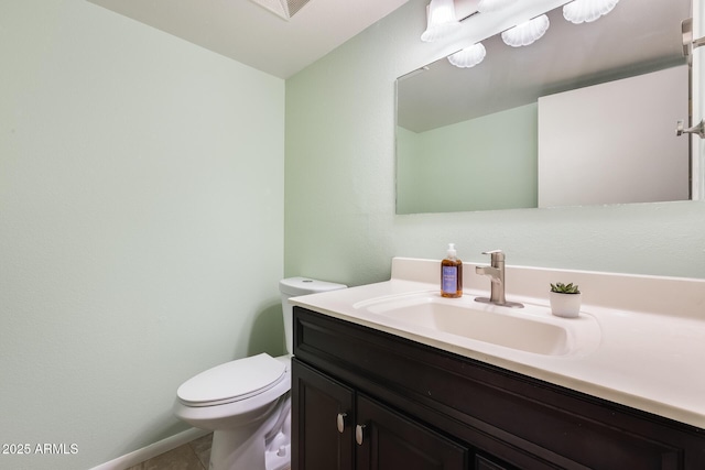 half bathroom featuring tile patterned floors, toilet, and vanity