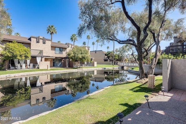 view of community featuring a lawn and a water view