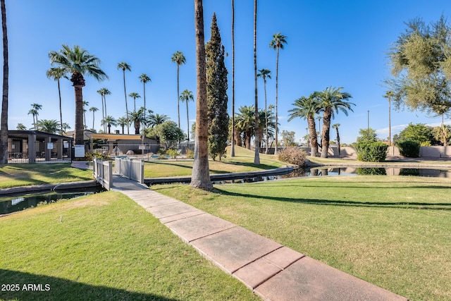 view of property's community with a lawn and a water view