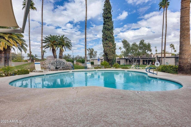 community pool with a patio and fence