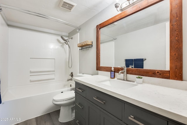 full bathroom featuring vanity, wood finished floors, visible vents, shower / tub combination, and toilet