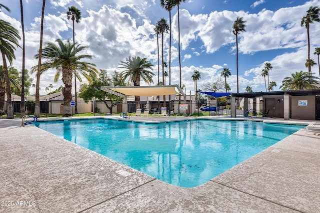 pool with a patio area and fence