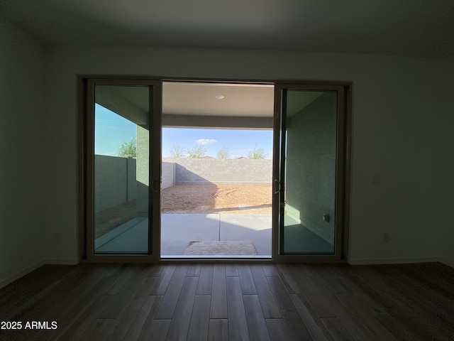 doorway featuring wood finished floors, a wealth of natural light, and baseboards