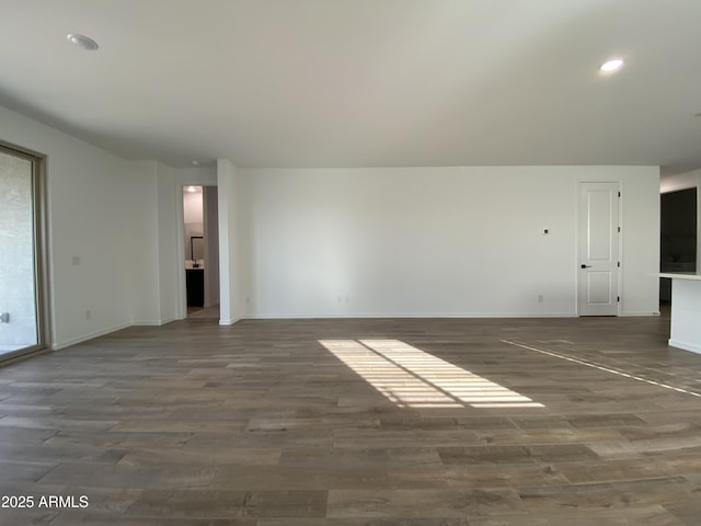 unfurnished living room featuring baseboards, wood finished floors, and recessed lighting